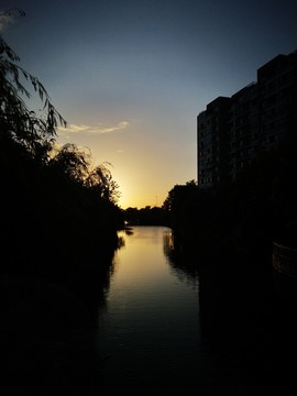 落日的余晖倒影在河面上