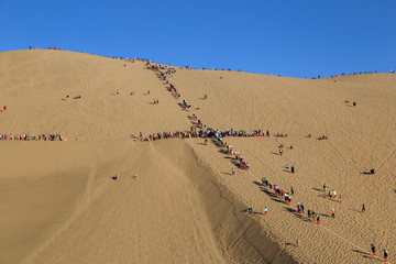 敦煌鸣沙山的游客在沙丘上