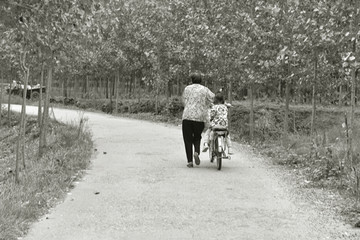 推自行车的老人与小孩