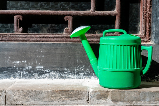一个绿色的塑料洒水壶