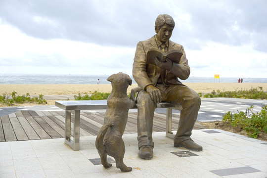 读书的男人和小狗雕塑