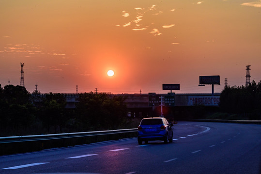夕阳落日高速公路行驶的汽车