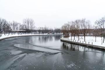 冬季河面结冰两岸树木光秃和白色