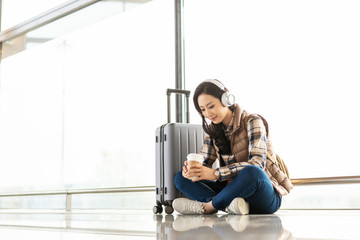 年轻女子在机场听音乐