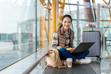 年轻女子在机场使用电脑