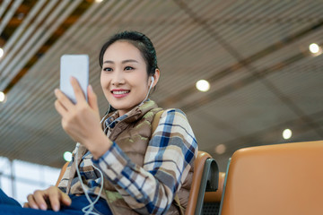 年轻女子在候机室使用手机