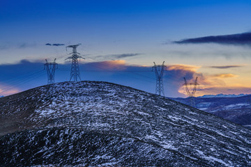 高原雪山夕阳高压电塔