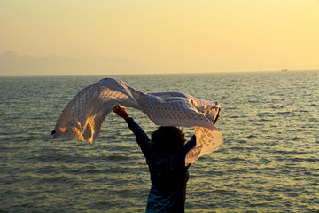 海边挥舞纱巾的女人