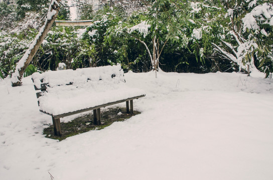 居民小区铺满雪的长凳