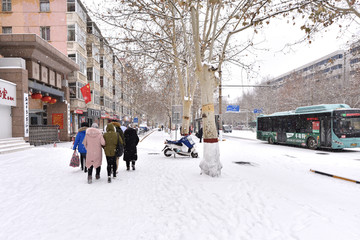 街道积雪和雪地上行走的人