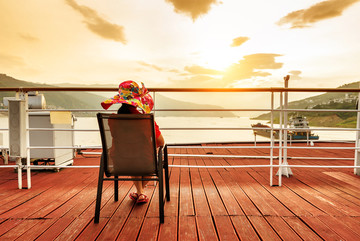 女人坐在游船甲板看风景