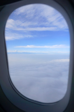 飞机舷窗外的山脉和蓝天白云