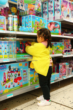 小女孩在商场选玩具陈列