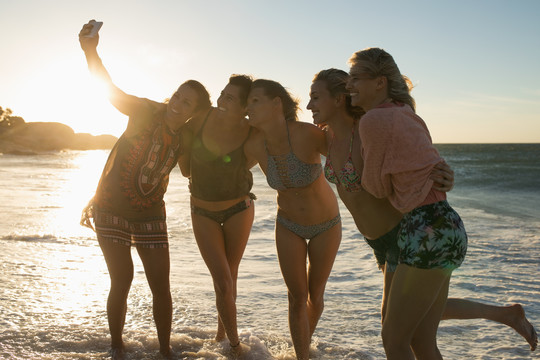 女子排球运动员在海滩用手机自拍