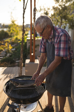 在后院烧烤做饭的老人
