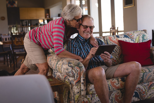 老年夫妇在家使用数字平板电脑