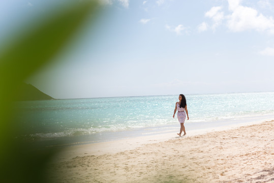 独自在海滩散步的女人