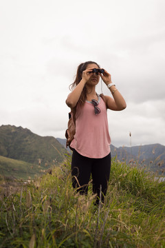 徒步旅行的女人用望远镜看风景