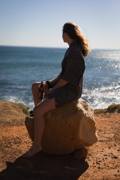 坐在沙滩石上的女人 
