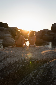 一对夫妇坐在海滩上的岩石上