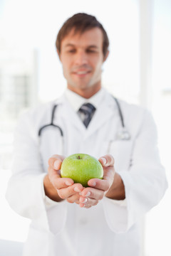 拿着青苹果的男医生