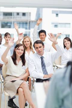一群同事在看演讲时举手示意