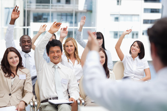 商人向同事举手示意，把注意力集中在同事身上。