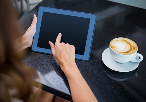 在咖啡店喝咖啡用平板电脑的女人