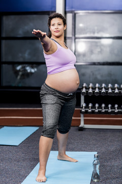在休闲中心在垫子上做运动的孕妇