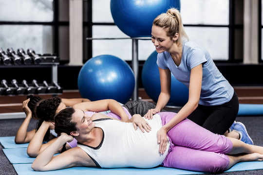 健身教练帮助孕妇进行训练