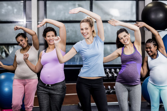 女教练带孕妇在休闲中心锻炼