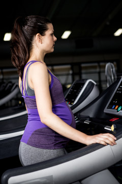 在健身房跑步机上的孕妇