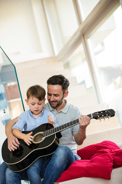 父亲在客厅教儿子弹吉他