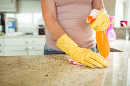 妇女用橡胶手套布清洁厨房台面