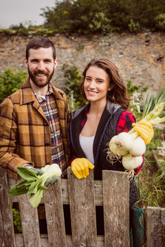 一对微笑的夫妇在农村展示蔬菜