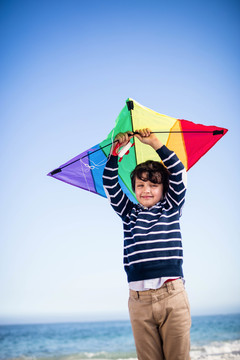 可爱的男孩在海滩上玩风筝
