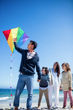 可爱的一家人在海滩上玩风筝