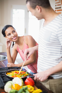 微笑的夫妇在厨房里准备蔬菜