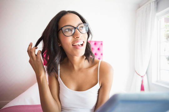 黑发女人用粉红卧室的平板电脑