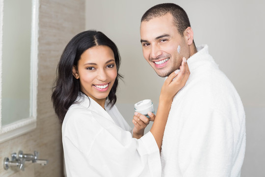 黑发女人在浴室里涂上丈夫的面霜