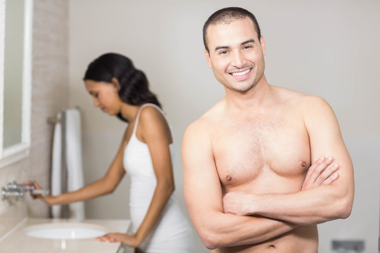 微笑的夫妇看着浴室里的镜子