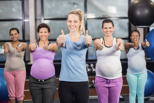 健身教练帮助孕妇进行训练