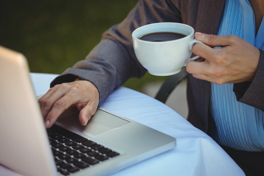 女人在咖啡馆用笔记本电脑喝咖啡