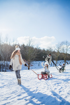 一家人在雪天玩雪橇