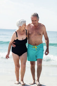 在海滩上散步的老年夫妇