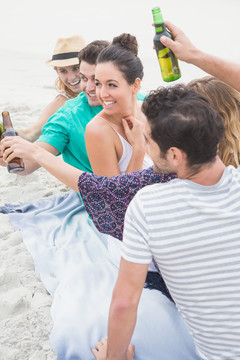 一群坐在沙滩上喝啤酒的朋友