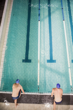两名游泳运动员跳入游泳池