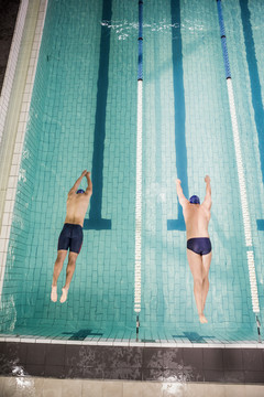 两名游泳运动员跳进游泳池