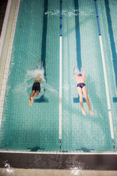 两名游泳运动员跳进游泳池