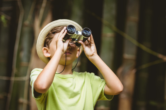 在森林里用望远镜看的小男孩
